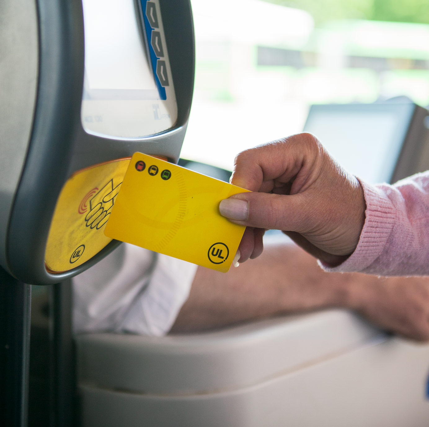 Hand med gult kort mot biljettläsare